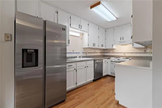 a kitchen with cabinets stainless steel appliances and a counter space
