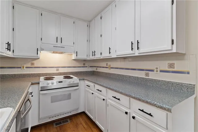 a kitchen with white cabinets and white appliances