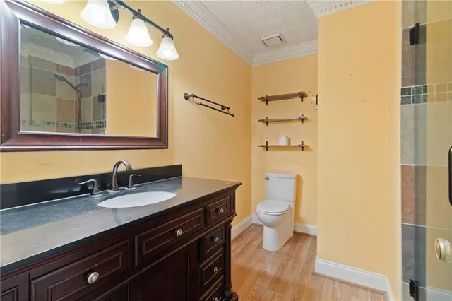 a bathroom with a granite countertop sink toilet and shower