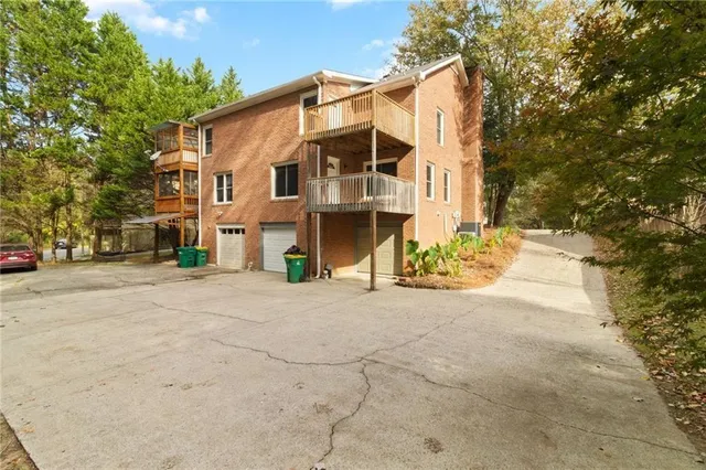 a view of a white house with a large tree