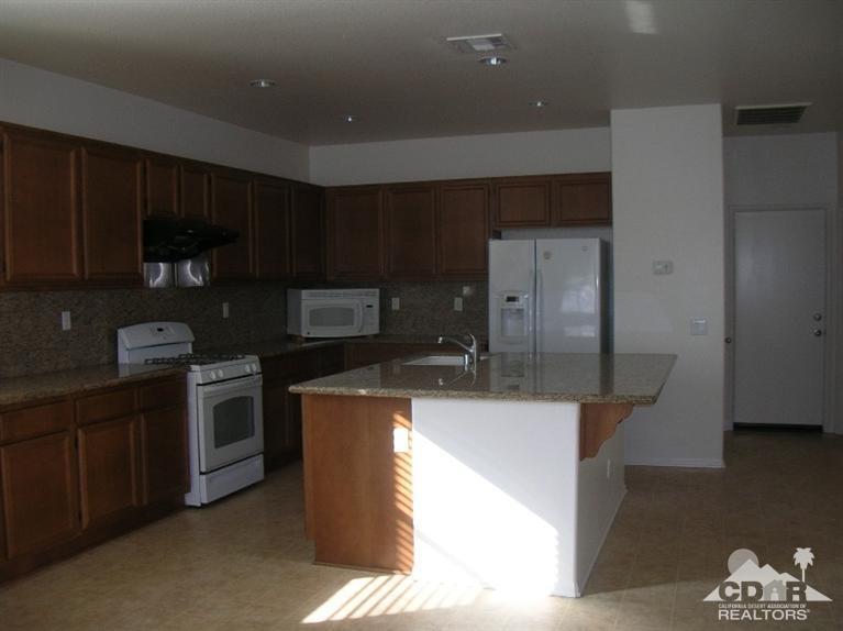 82797 Mount Riley Drive Indio, CA 92203 - Photo 3 of 17 a kitchen with kitchen island granite countertop a sink stainless steel appliances and cabinets