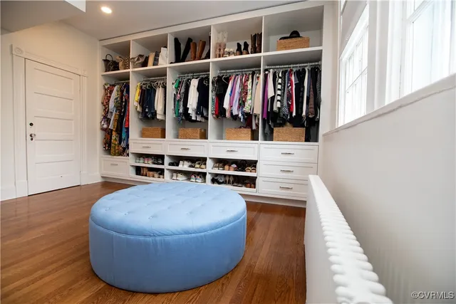 a view of walk in closet with clothes and shoes