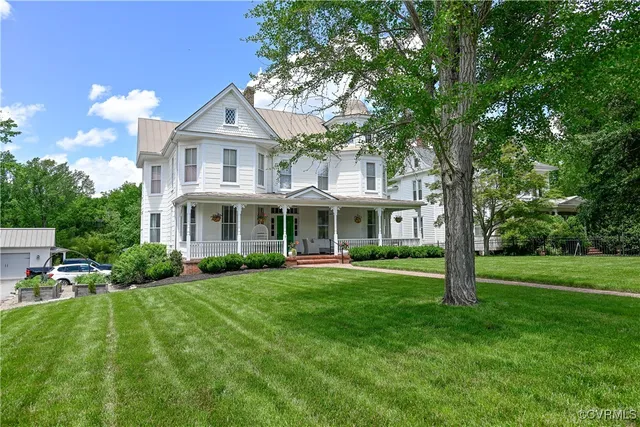a front view of a house with a garden and trees