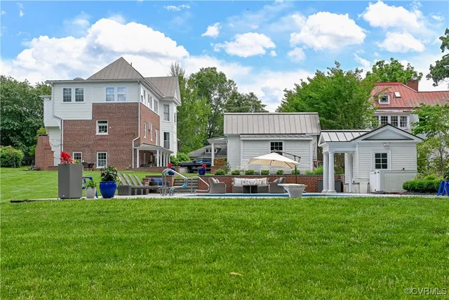 a view of a house with backyard and sitting area