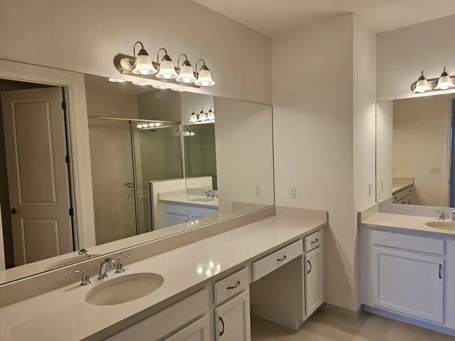 a bathroom with a sink double vanity and a mirror