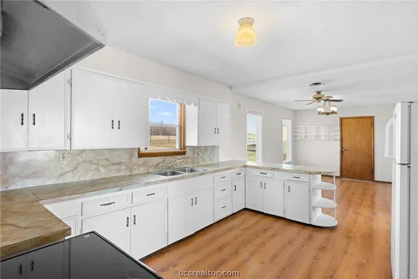 a kitchen with granite countertop white cabinets and a sink