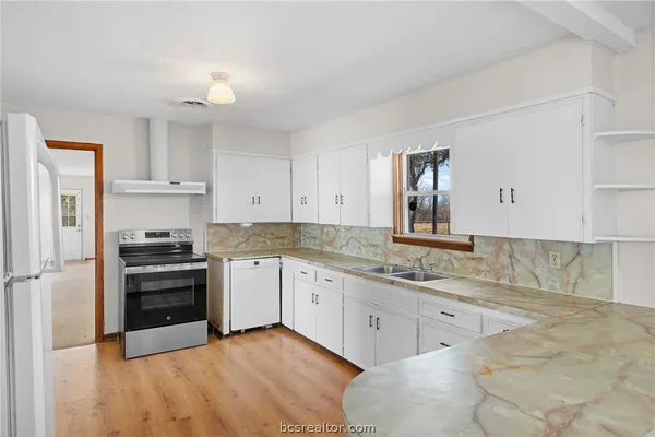 a kitchen with a sink stove and cabinets