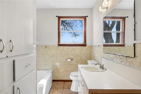 a bathroom with a sink and mirror with toilet