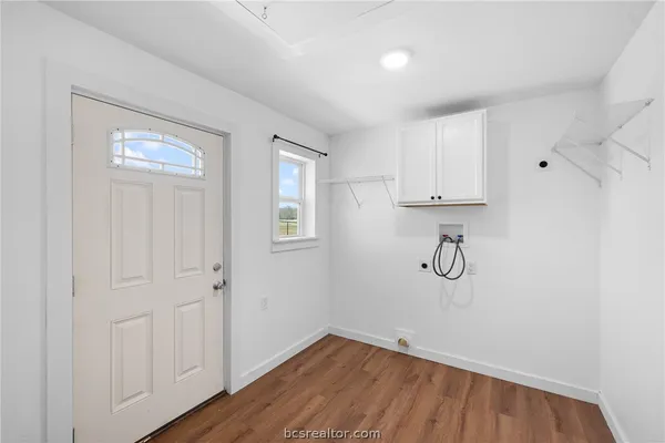 a view of a room with wooden floor and cabinets