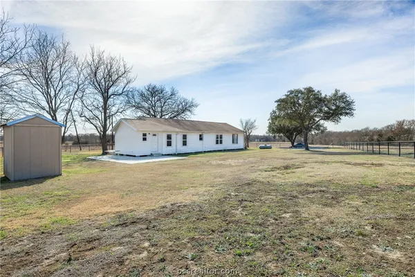 a large white building with trees in the background