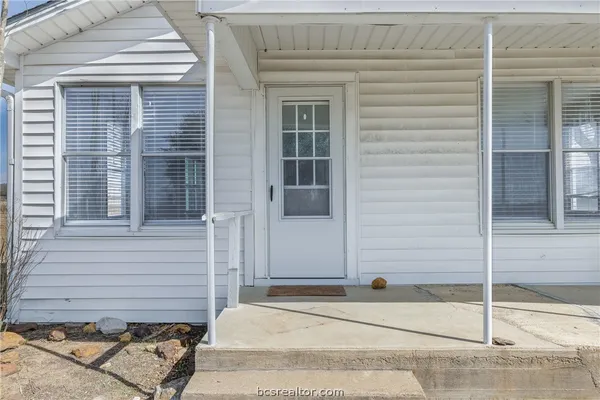 a side view of a house with a door and a window