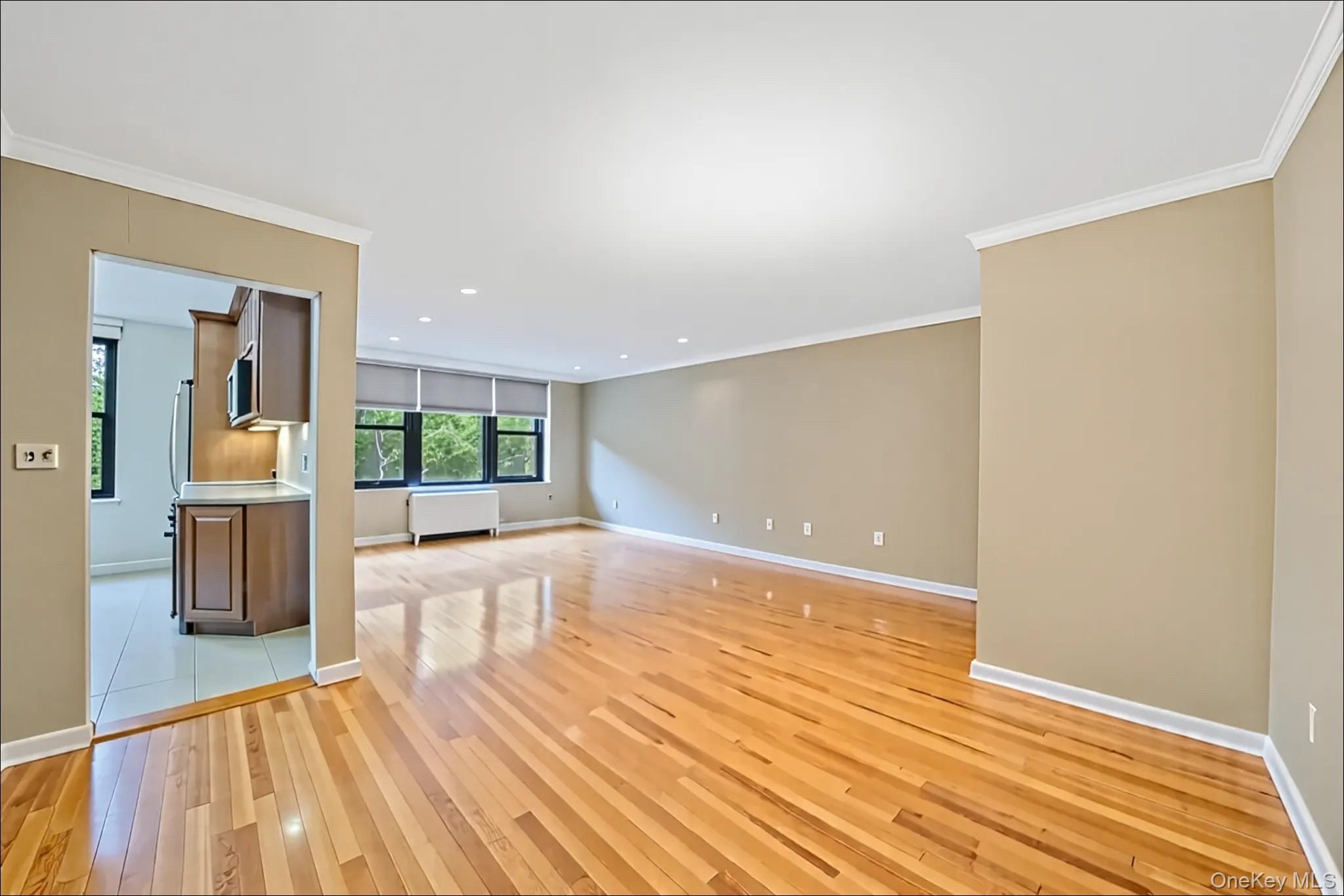 18-35 Corporal Kennedy Street, Unit 2B Queens, NY 11360 - Photo 2 of 25 a view of a living room a dining room with wooden floor and a rug