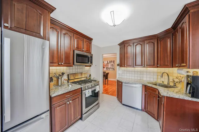 a kitchen with stainless steel appliances granite countertop a refrigerator stove and sink