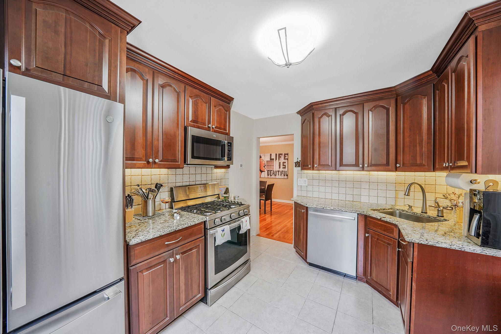 18-35 Corporal Kennedy Street, Unit 2B Queens, NY 11360 - Photo 6 of 25 a kitchen with stainless steel appliances granite countertop a refrigerator stove and sink
