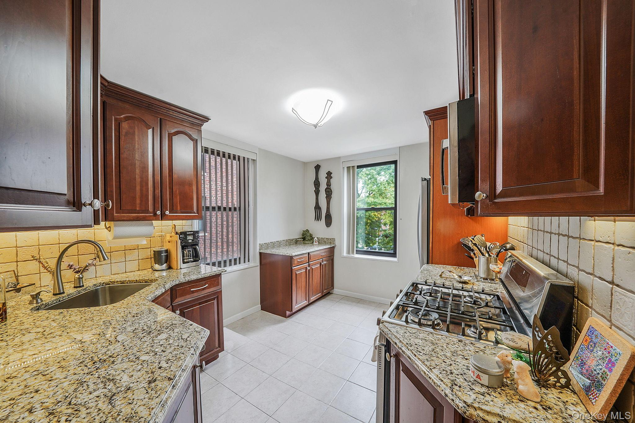 18-35 Corporal Kennedy Street, Unit 2B Queens, NY 11360 - Photo 7 of 25 a kitchen with a stove a sink and a refrigerator