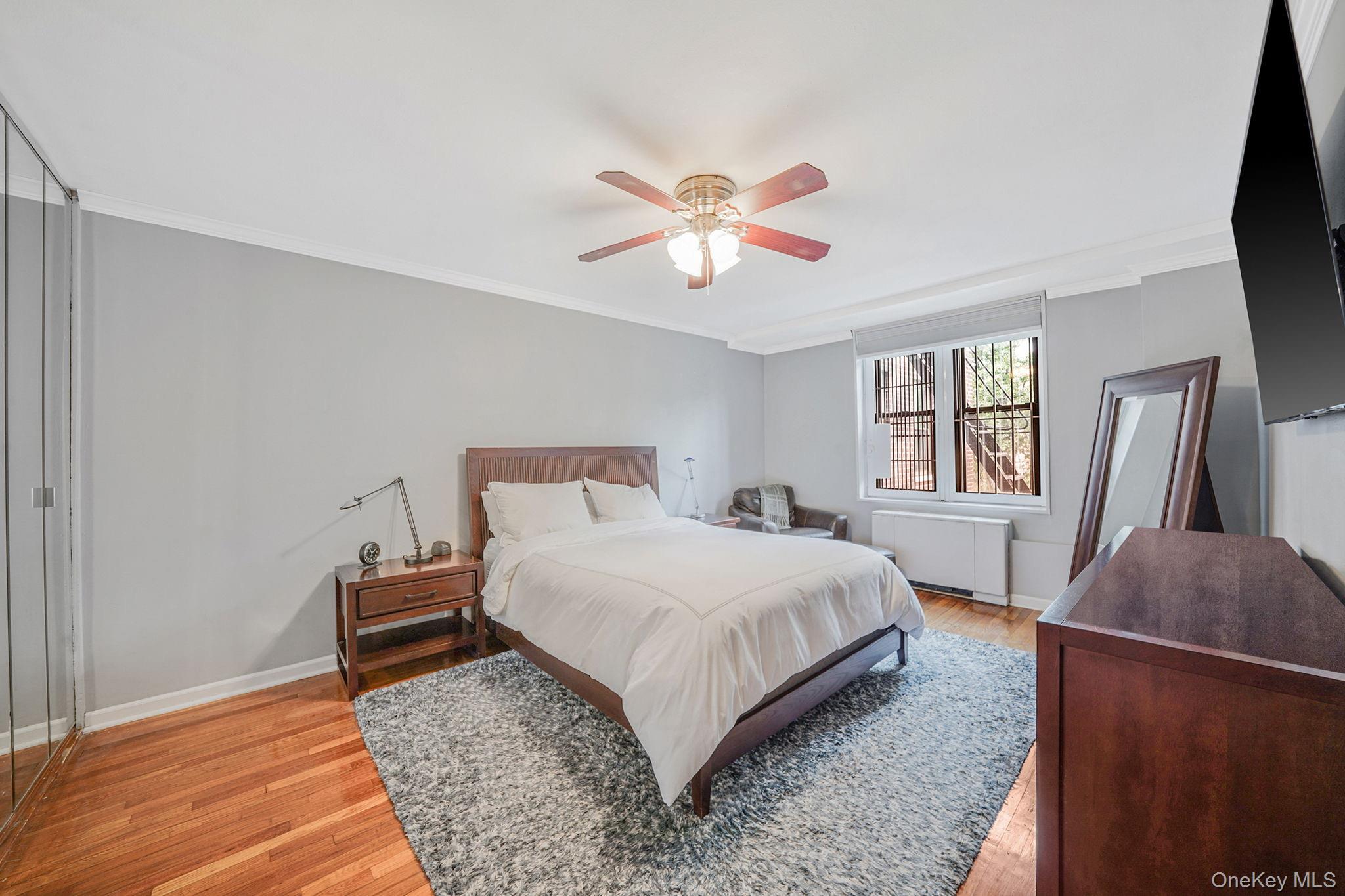 18-35 Corporal Kennedy Street, Unit 2B Queens, NY 11360 - Photo 10 of 25 a bedroom with a bed and a chandelier