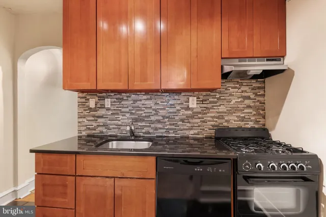 a kitchen with granite countertop a stove a cabinets and a sink