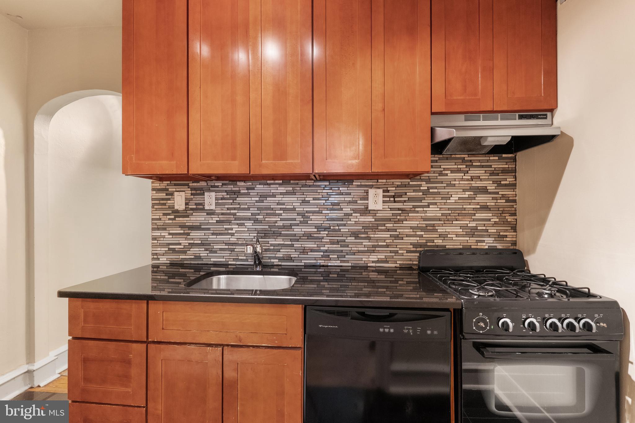 2433 Fairmount Avenue, Unit 1 Philadelphia, PA 19130 - Photo 6 of 13 a kitchen with granite countertop a stove a cabinets and a sink