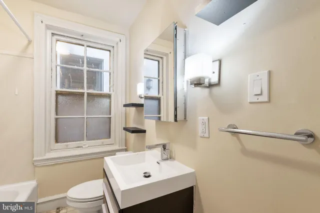 a bathroom with a sink mirror and toilet