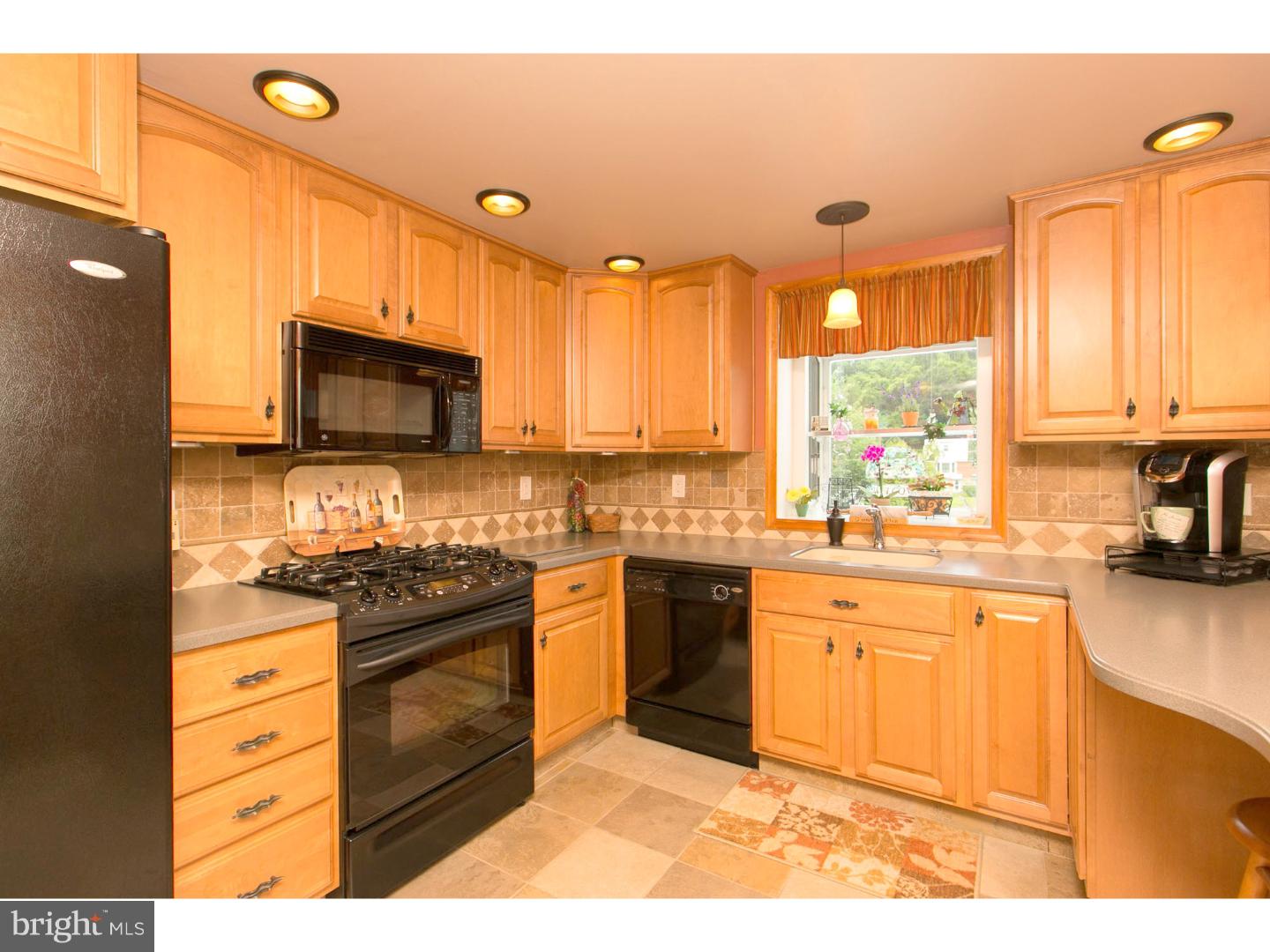 8610 Bridle Road Philadelphia, PA 19115 - Photo 2 of 25 a kitchen with stainless steel appliances granite countertop a stove a sink and a microwave