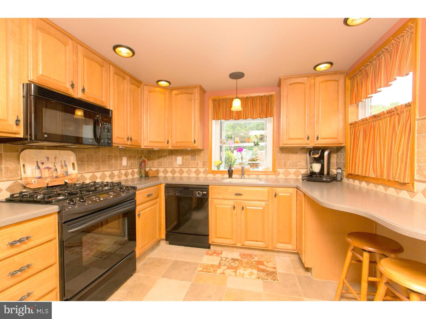 8610 Bridle Road Philadelphia, PA 19115 - Photo 5 of 25 a kitchen with stainless steel appliances granite countertop a stove a sink and a microwave