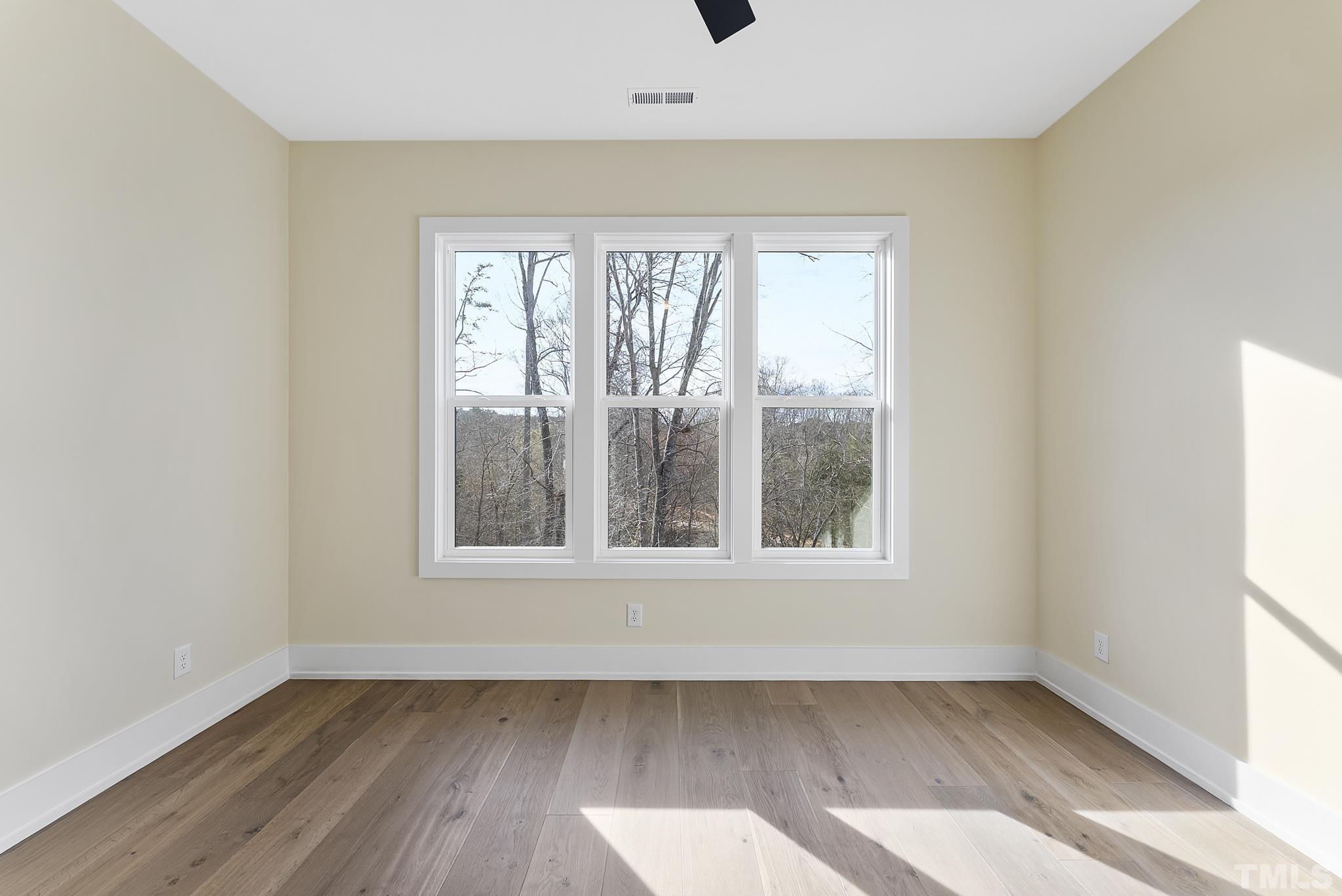 4910 Poyner Road Raleigh, NC 27612 - Photo 21 of 48 an empty room with wooden floor and windows