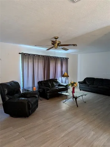a living room with furniture and a ceiling fan