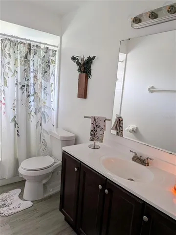 a bathroom with a double vanity sink toilet and a mirror