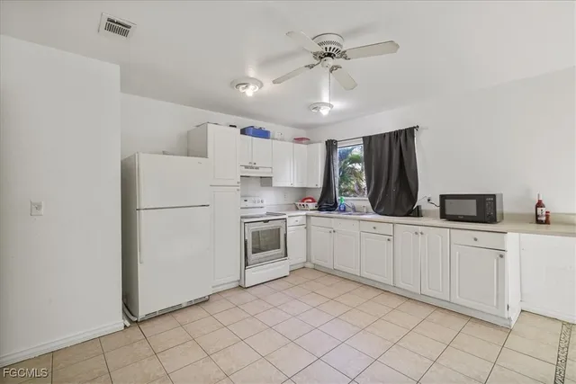 a kitchen with white cabinets and white appliances