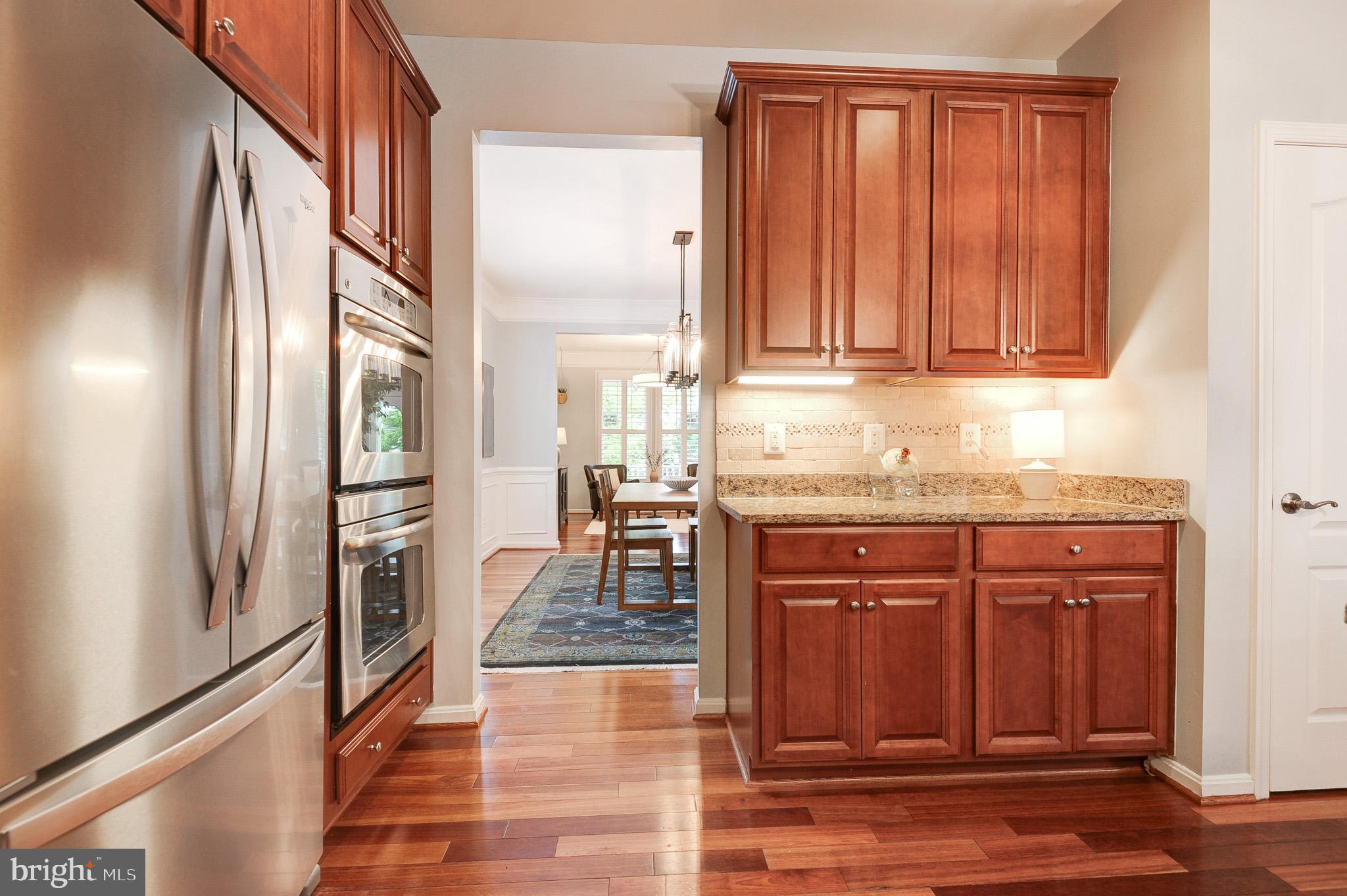 23372 Minerva Drive Brambleton, VA 20148 - Photo 15 of 61 an empty room with wooden floor and cabinet