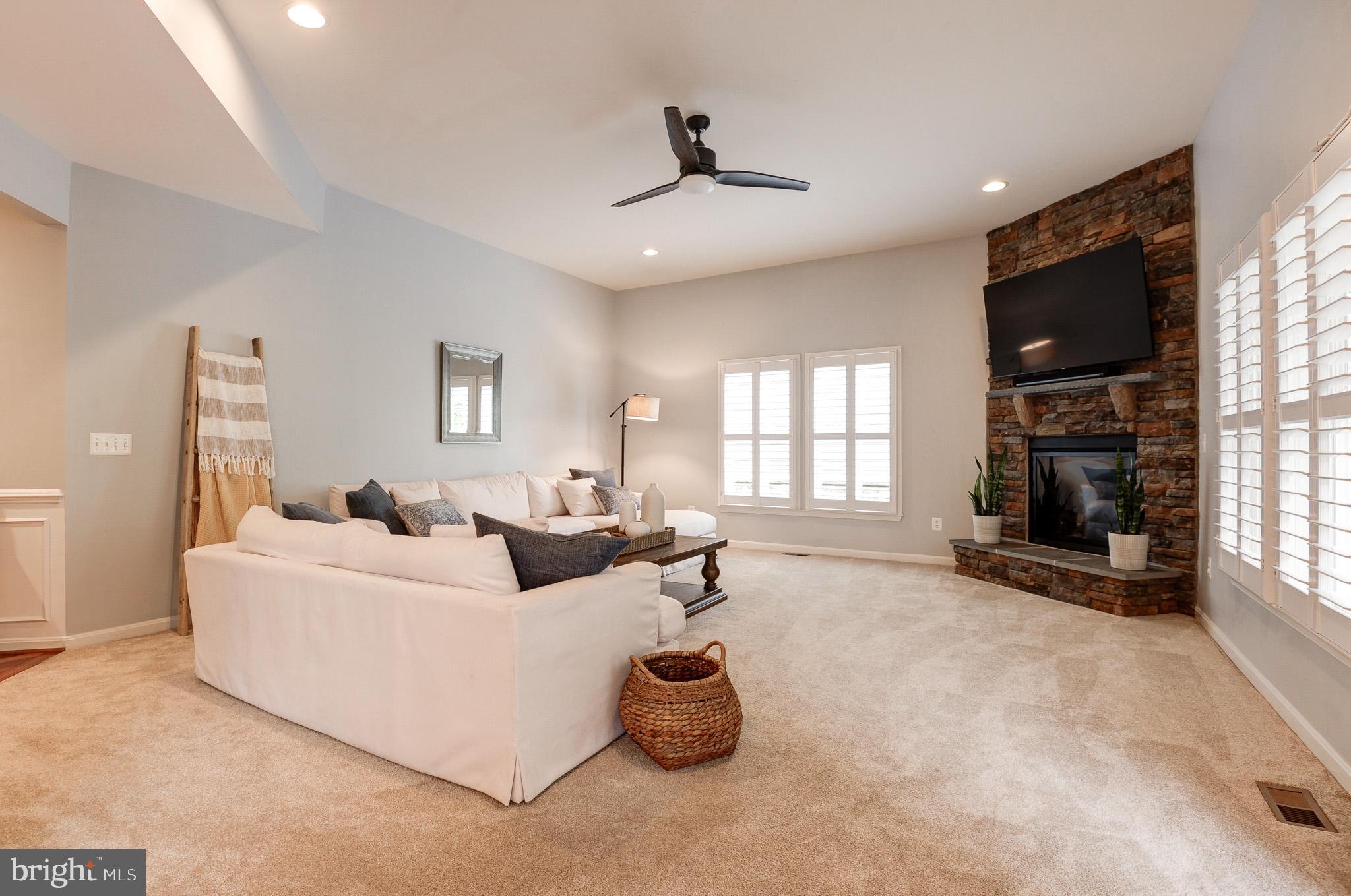 23372 Minerva Drive Brambleton, VA 20148 - Photo 18 of 61 a living room with furniture a flat screen tv and a fireplace
