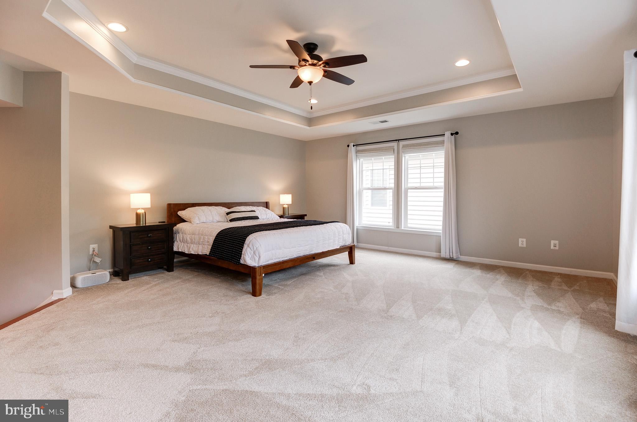 23372 Minerva Drive Brambleton, VA 20148 - Photo 30 of 61 a spacious bedroom with a bed and a ceiling fan