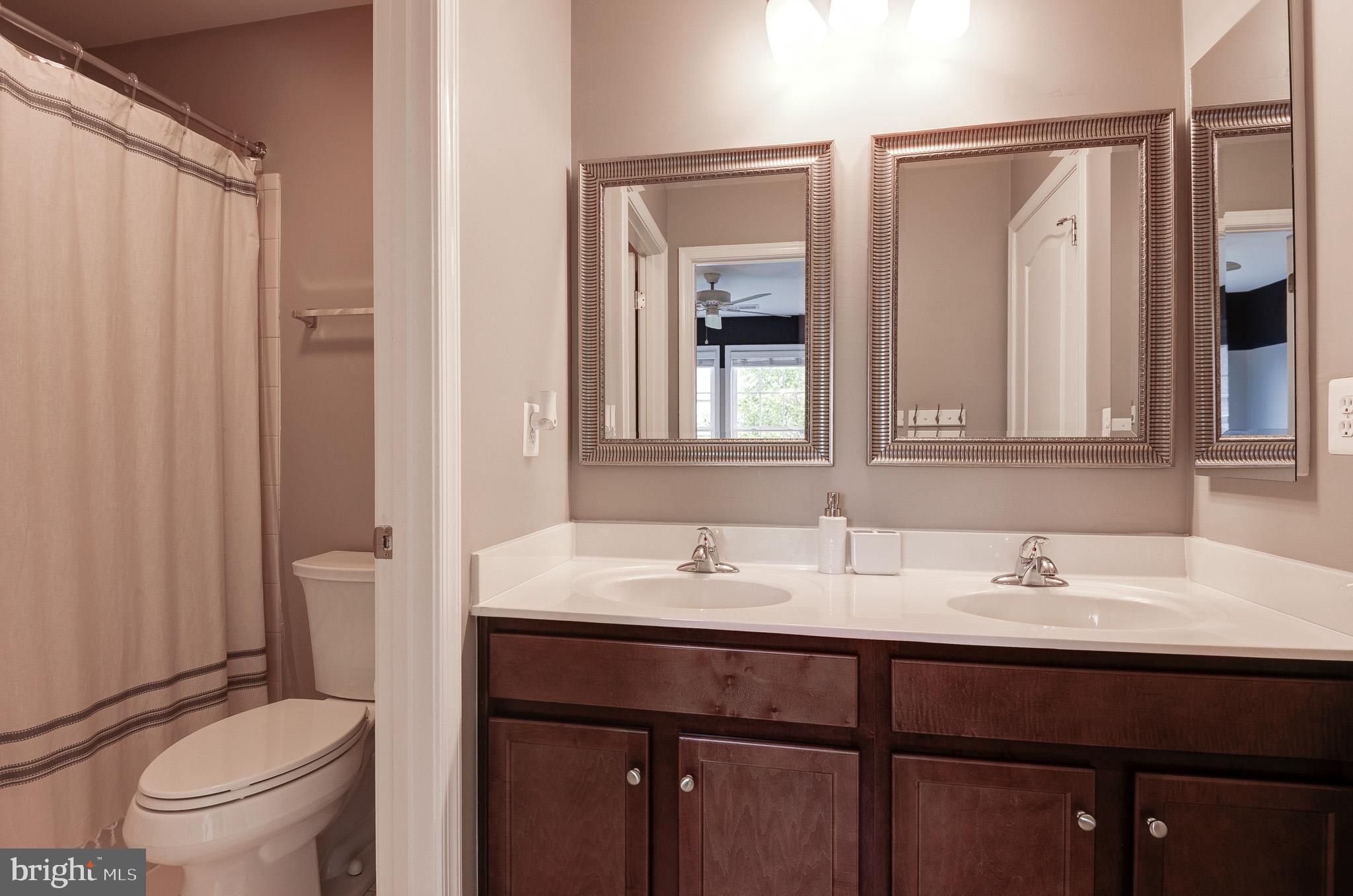 23372 Minerva Drive Brambleton, VA 20148 - Photo 40 of 61 a bathroom with a granite countertop sink toilet a mirror and shower