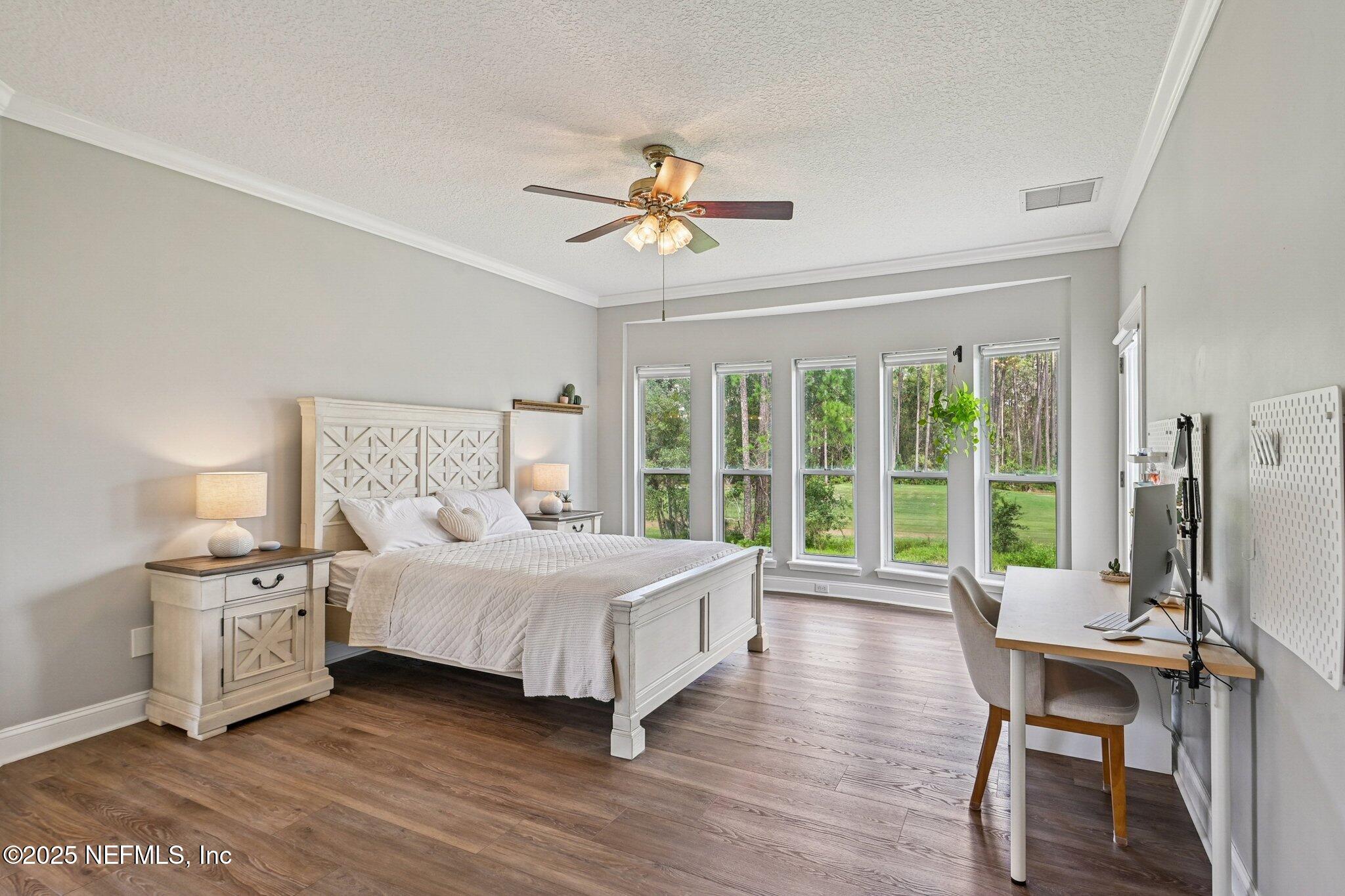 2300 Spring Hill Court Fleming Island, FL 32003 - Photo 18 of 45 a bedroom with a bed wooden floor and a large window