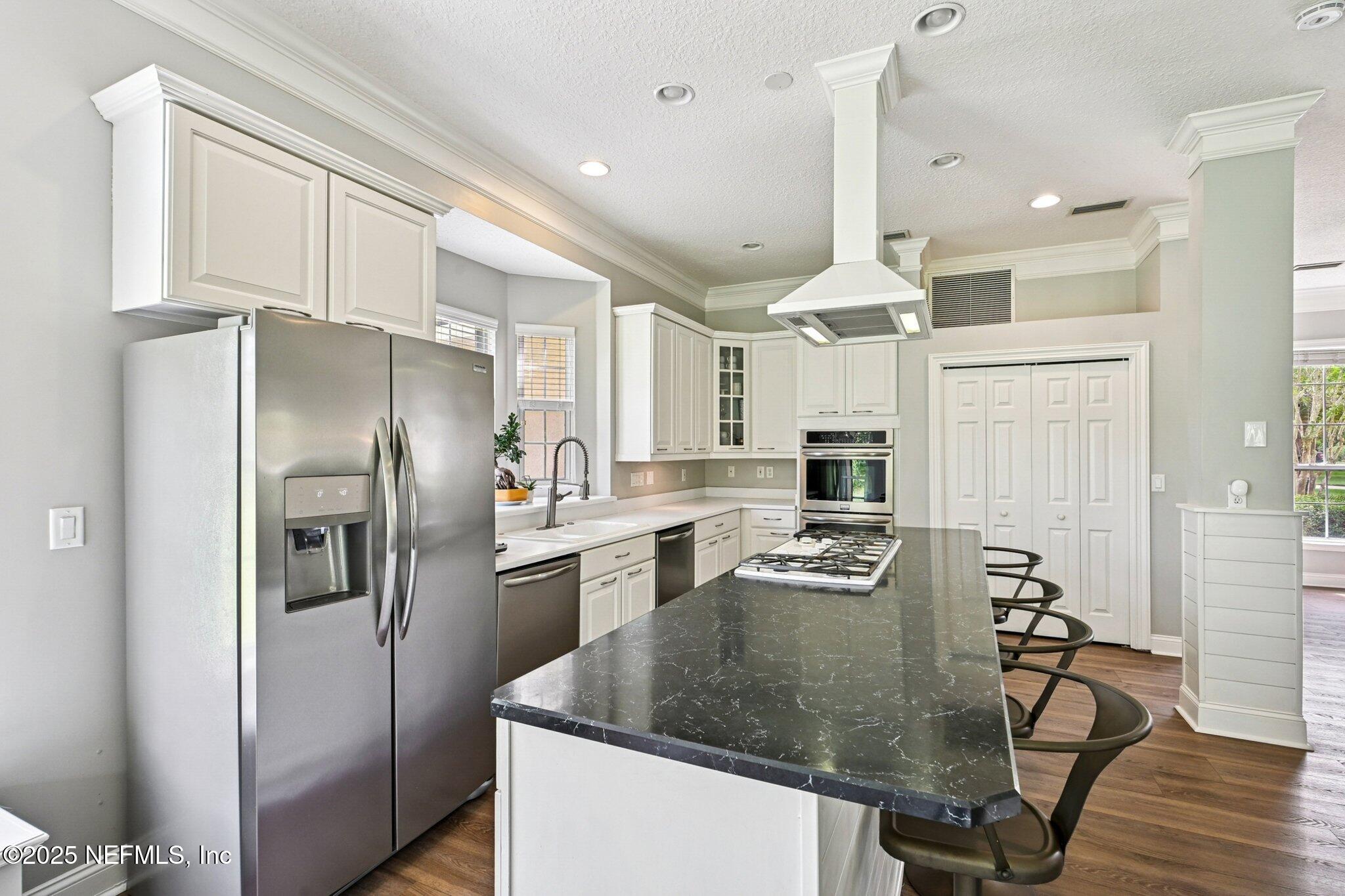 2300 Spring Hill Court Fleming Island, FL 32003 - Photo 5 of 45 a kitchen with stainless steel appliances granite countertop a refrigerator a stove and a sink with wooden floor