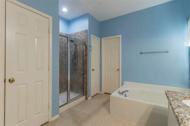 a bathroom with a tub a shower and a sink