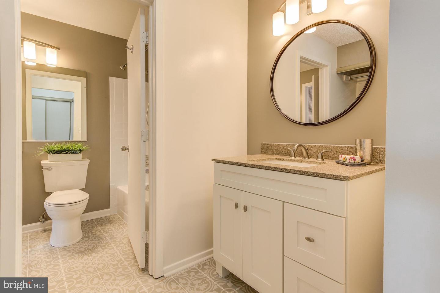 11707 D Summerchase Circle Reston, VA 20194 - Photo 18 of 21 a bathroom with a granite countertop toilet a sink and a mirror