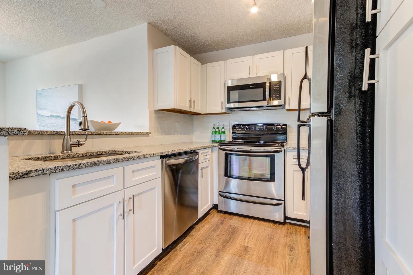 11707 D Summerchase Circle Reston, VA 20194 - Photo 7 of 21 a kitchen with stainless steel appliances granite countertop a stove a sink and a refrigerator