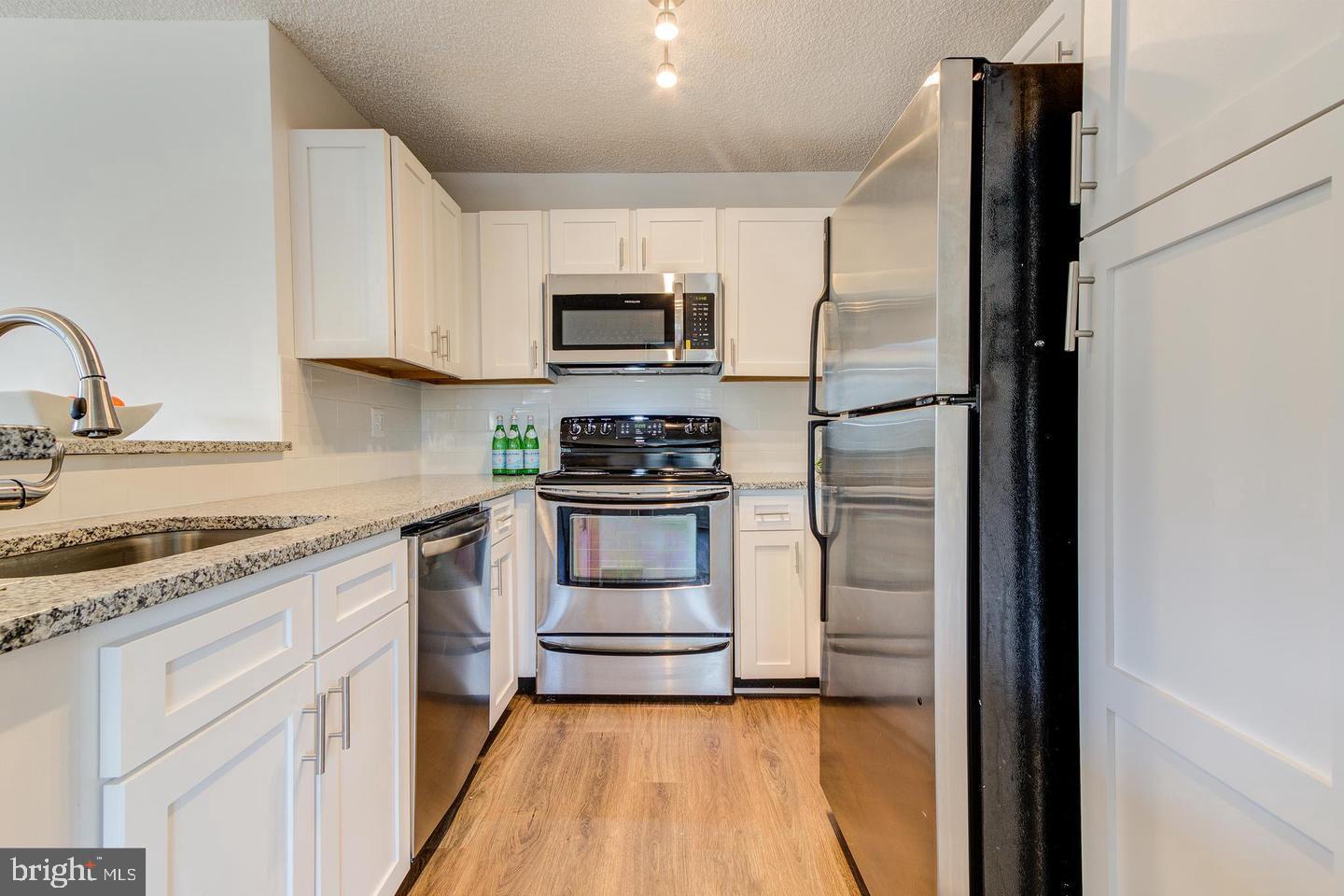 11707 D Summerchase Circle Reston, VA 20194 - Photo 8 of 21 a kitchen with stainless steel appliances granite countertop a refrigerator and a stove top oven