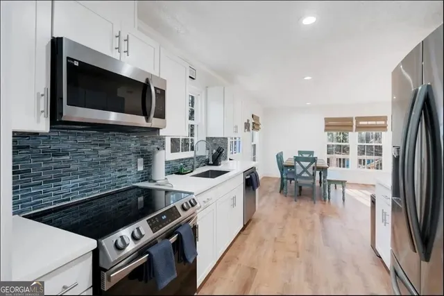 a kitchen with stainless steel appliances a stove a sink and a microwave
