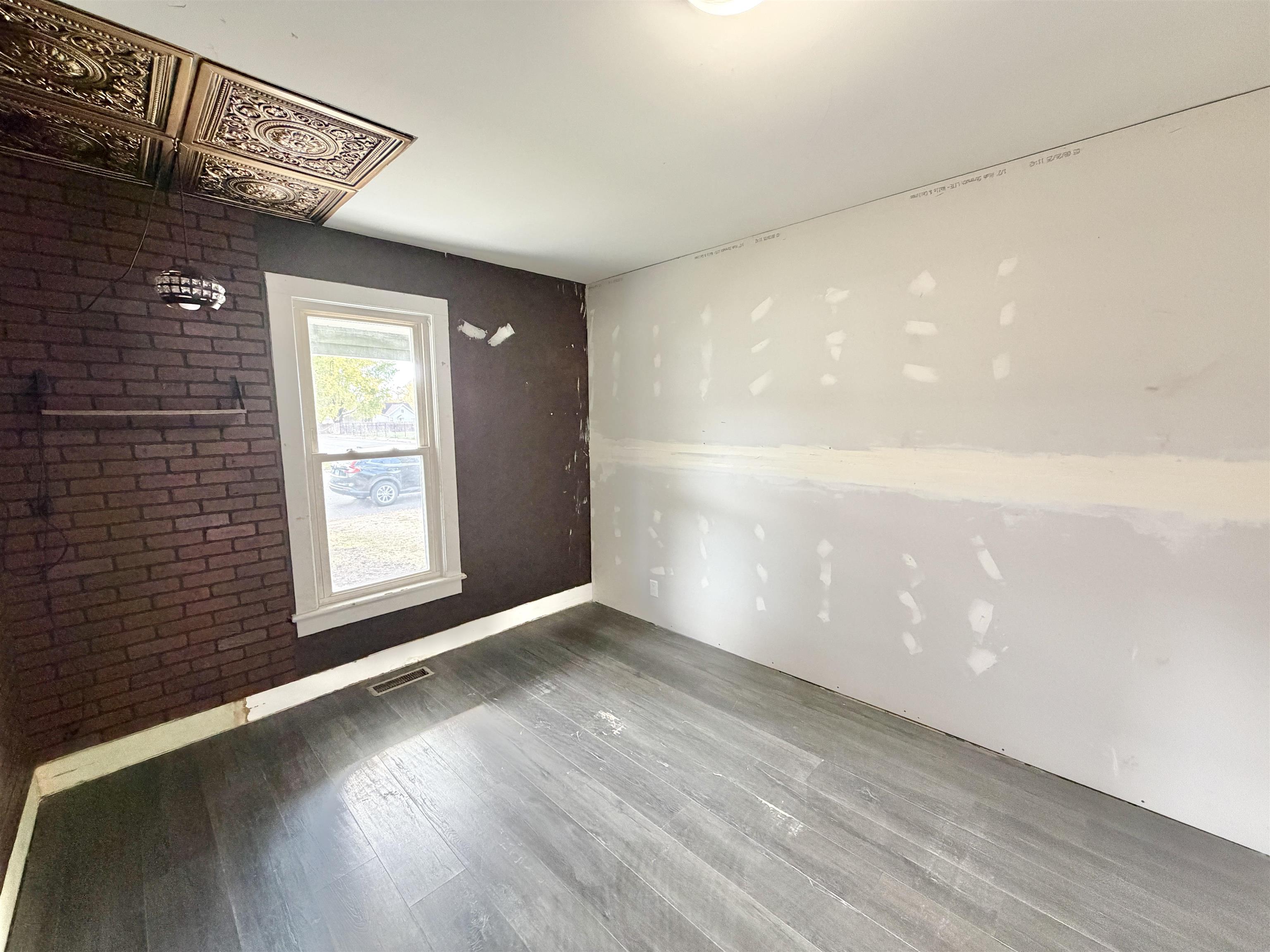 423 West 4th Street Byron, IL 61010 - Photo 11 of 31 a view of an empty room with wooden floor and a window