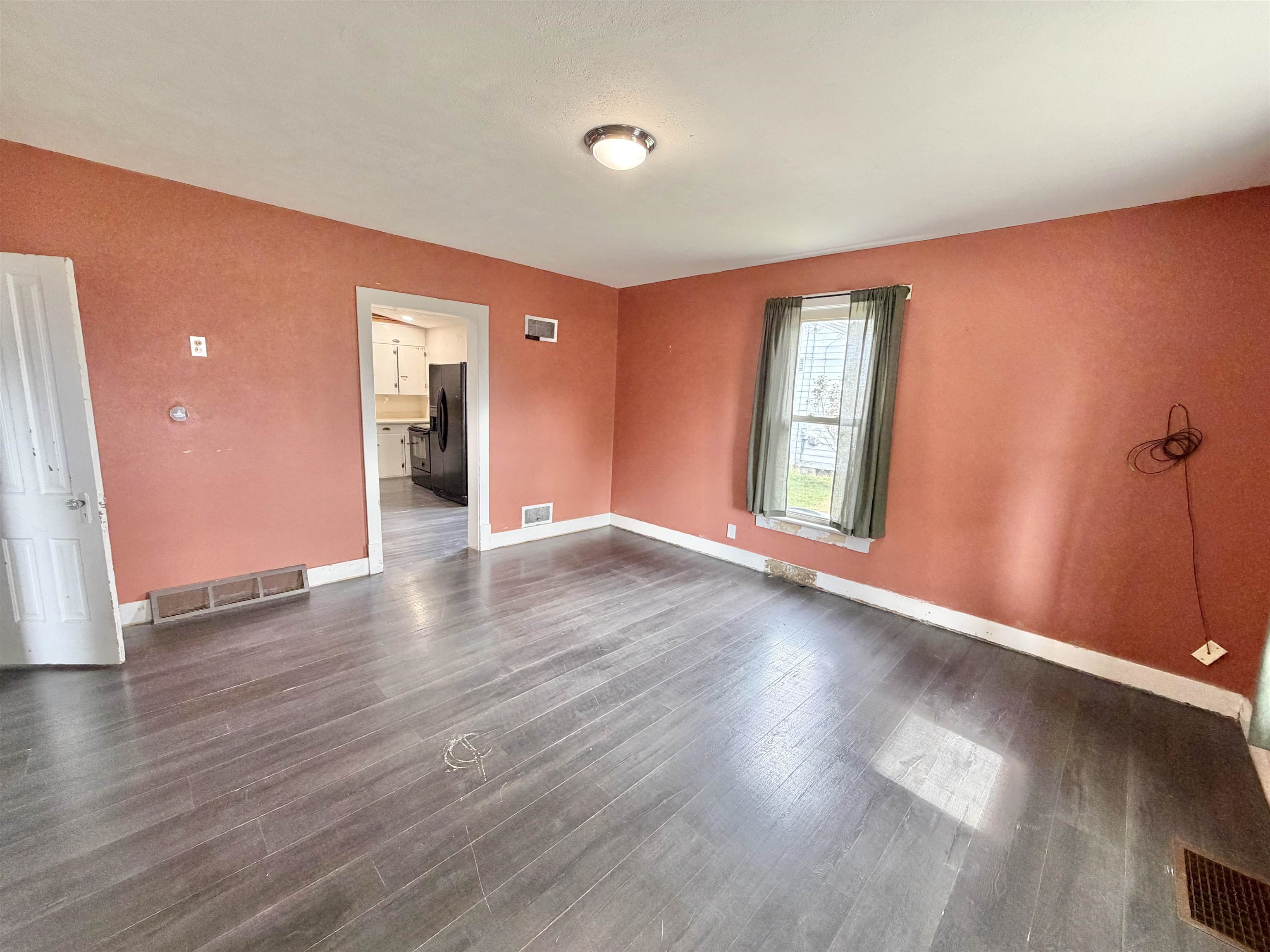 423 West 4th Street Byron, IL 61010 - Photo 5 of 31 an empty room with wooden floor and windows