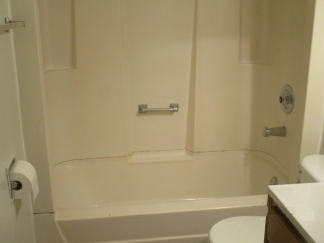 101 Prairie Street Ottawa, IL 61350 - Photo 11 of 15 a bathroom with a granite countertop bathtub shower and toilet