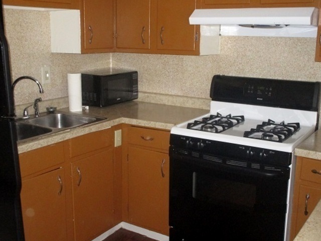 101 Prairie Street Ottawa, IL 61350 - Photo 6 of 15 a kitchen with a sink and a stove with wooden floor