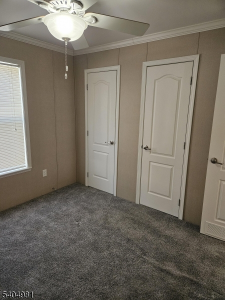 44 Ridge Road, Unit 13 Oak Ridge, NJ 07438 - Photo 8 of 17 an empty room with a chandelier fan and closet area
