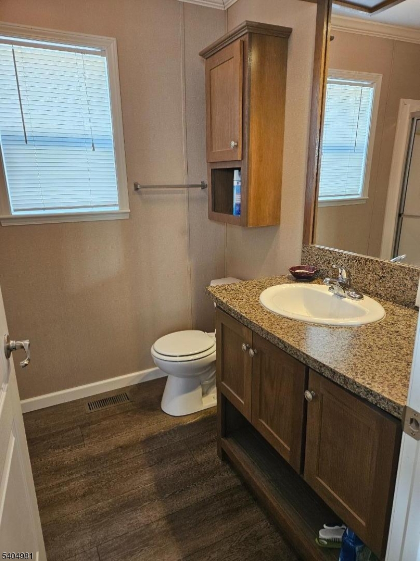 44 Ridge Road, Unit 13 Oak Ridge, NJ 07438 - Photo 9 of 17 a bathroom with a granite countertop sink toilet and mirror