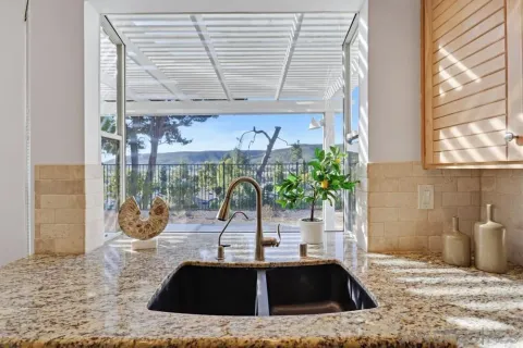 a view of a sink a counter space and a window