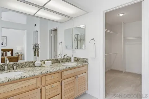 a bathroom with double vanity sinks and a shower