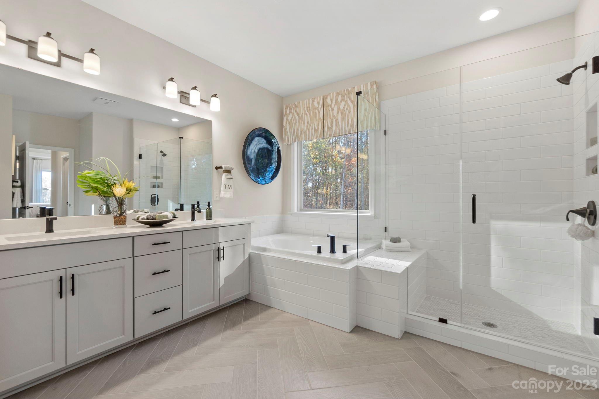 13220 Chopin Ridge Road Huntersville, NC 28078 - Photo 16 of 29 a spacious bathroom with a double vanity sink a mirror a bathtub and shower