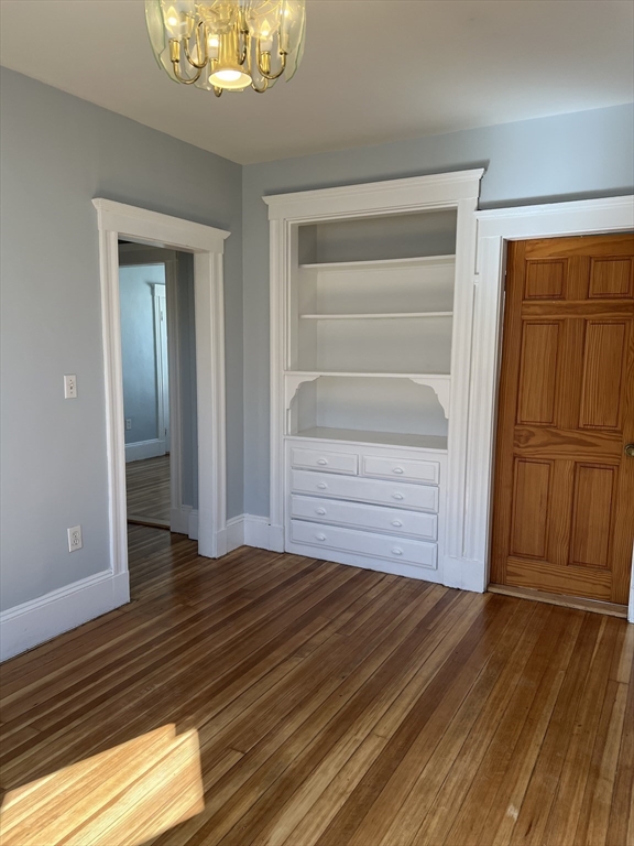 a view of a bedroom with wooden floor and closet